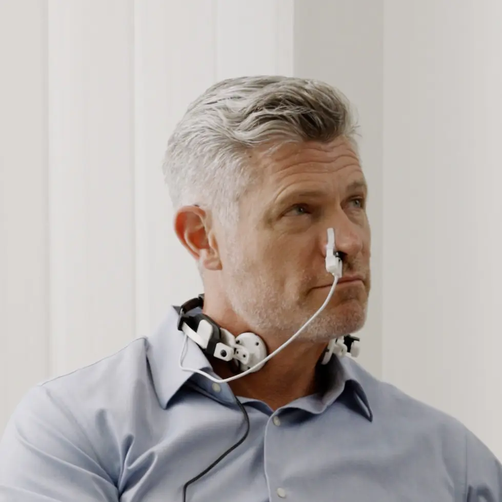Man wearing the Vielight Vagus neck and intranasal photobiomodulation components